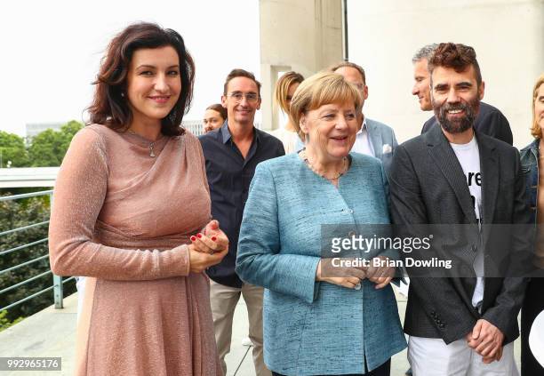 Dorothee Baer, German Federal Chancellor Angela Merkel, and designer Lutz Huelle attend the Fashion Council Germany reception at Bundeskanzleramt on...