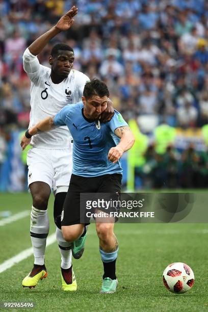 France's midfielder Paul Pogba vies with Uruguay's midfielder Cristian Rodriguez during the Russia 2018 World Cup quarter-final football match...