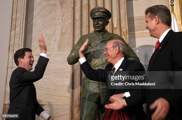 Sam Brownback,R-KS., Pat Roberts, R-KS., and Todd Tiahrt, R-KS., celebrate after pulling down the sheet for the presentation of statue during the...