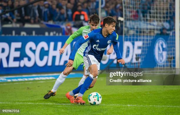 Schalke's Amine Harit and Wolfsburg's Paul Verhaegh vie for the ball during the Bundesliga soccer match between FC Schalke 04 and VfL Wolfsburg in...