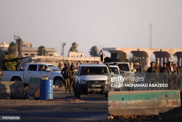 Picture taken on July 6, 2018 shows Syrian government soldiers arriving at the Nassib border crossing with Jordan in the southern province of Daraa,...