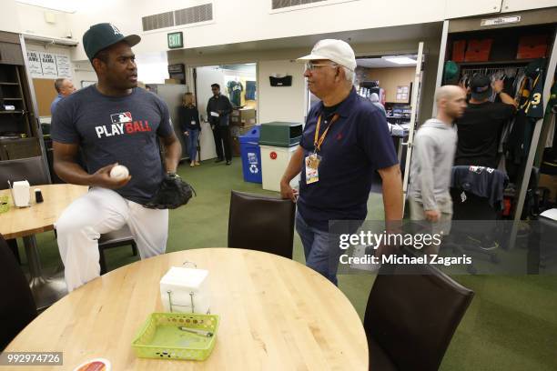 Santiago Casilla of the Oakland Athletics talks with Broadcaster Manolo Hernández-Douen in the clubhouse prior to the game against the Kansas City...