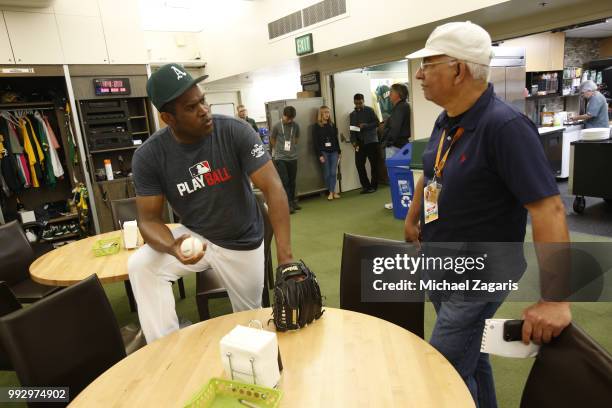 Santiago Casilla of the Oakland Athletics talks with Broadcaster Manolo Hernández-Douen in the clubhouse prior to the game against the Kansas City...