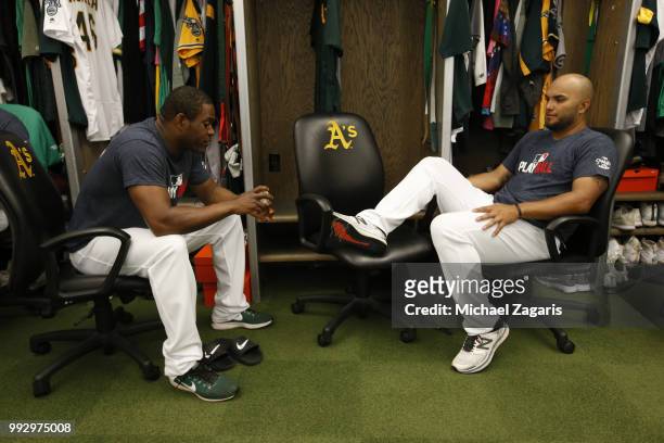 Santiago Casilla and Yusmeiro Petit of the Oakland Athletics talk in the clubhouse prior to the game against the Kansas City Royals at the Oakland...
