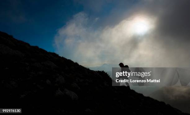 silhouette of a hiker on the mountain ridge at sunrise, mount strega, apennines, marche, italy - strega stockfoto's en -beelden