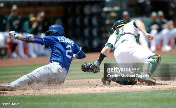 Josh Phegley of the Oakland Athletics tags Alcides Escobar of the Kansas City Royals out at home during the game at the Oakland Alameda Coliseum on...