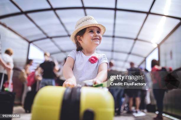 cheerful and excited toddler with her coffer on a airport - family at airport stock pictures, royalty-free photos & images