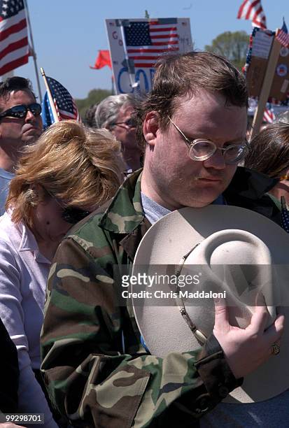 John Mann, from Falls Church, Va., removes his hat during a reading of the names of all the U.S. Soldiers killed in Iraq at pro-war rally sponsored...