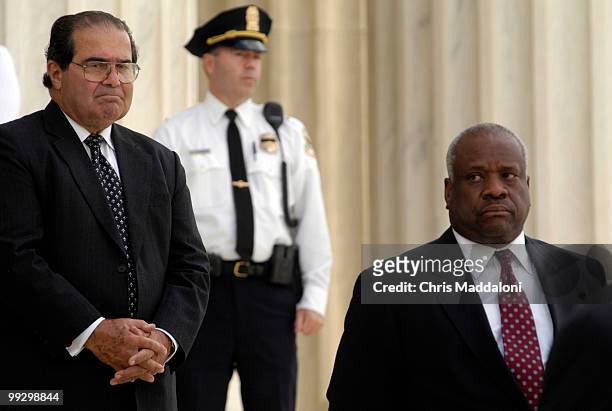Associate Justices Antonin Scalia and Clarence Thomas stand on the steps of the Supreme Court as pallbearers carry the casket of Chief Justice of the...