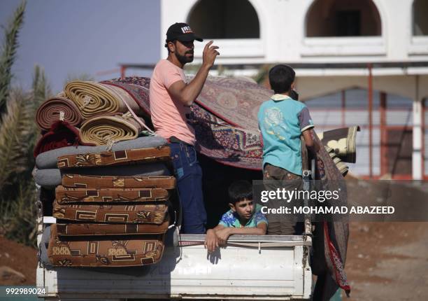 Syrian family returns to their homes in towns and villages situated on the eastern outskirts of Daraa on July 6, 2018. - The Syrian regime reached a...