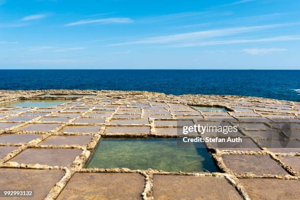 sea salt extraction in salt pans, xwejni bay, gozo, malta - tsukubai fotografías e imágenes de stock