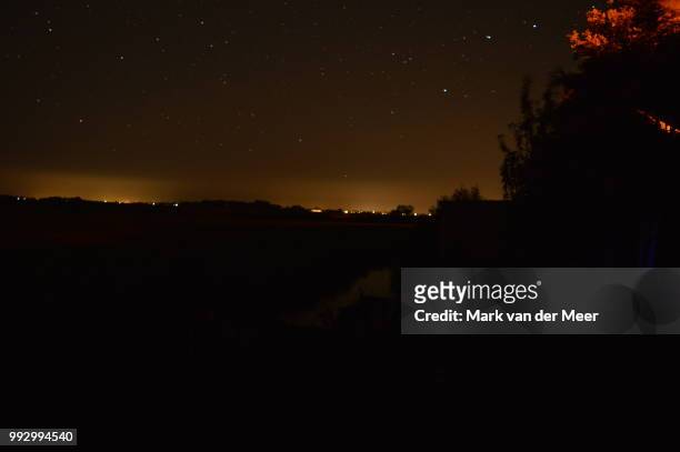 countyside with city lights - meer stock pictures, royalty-free photos & images