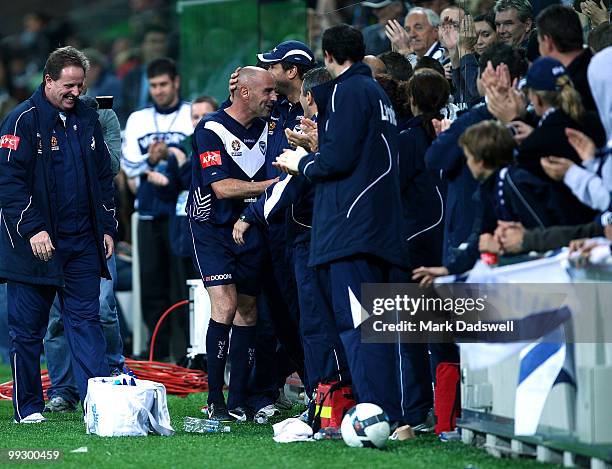 Kevin Muscat of the Victory is congratulated by teammates on the bench after being subbed off during the Kevin Muscat Testimonial match between...