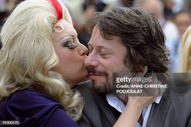 Actress Dirty Martini kisses French director and actor Mathieu Amalric during the photocall of the film "Tournee" presented in competition at the...