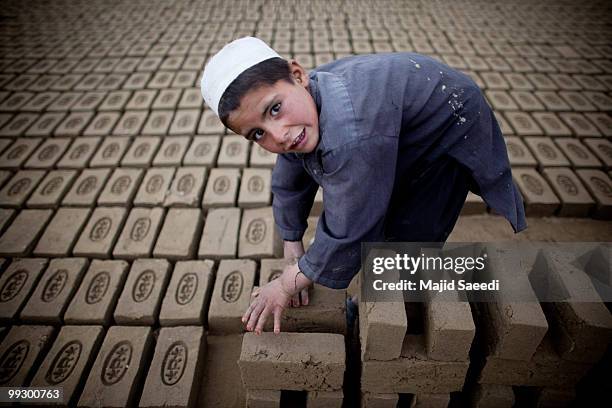 An Afghan child sorts bricks at the Sadat Ltd. Brick factory, where he works from 8am to 5 pm daily, on May 14, 2010 in Kabul, Afghanistan. Child...