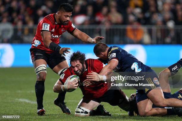 Sam Whitelock of the Crusaders is tackled during the round 18 Super Rugby match between the Crusaders and the Highlanders at AMI Stadium on July 6,...