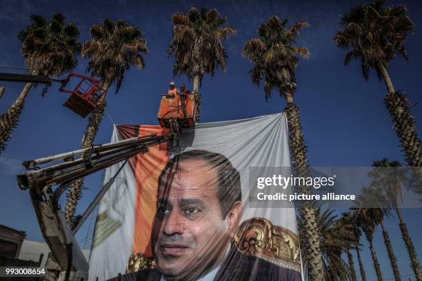 Dpatop - Palestinians hang a portrait of Egyptian President Abdel Fattah al-Sisi at the Rafah border crossing between Egypt and Gaza in Rafah,...