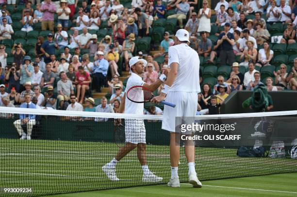 Player John Isner greets Moldova's Radu Albot after winning 6-3, 6-3, 6-4 in their men's singles third round match on the fifth day of the 2018...