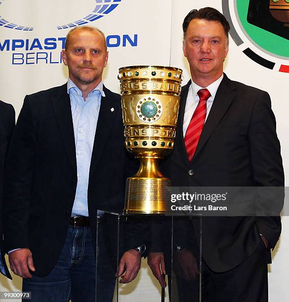Head coach Thomas Schaaf of Werder Bremen and head coach Louis van Gaal of Bayern Muenchen pose with the trophy during a press conference prior to...