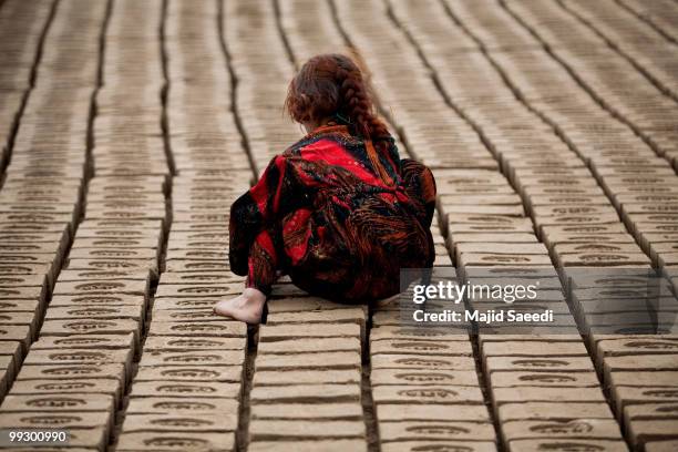 An Afghan child works at the Sadat Ltd. Brick factory, where she works from 8am to 5 pm daily, on May 14, 2010 in Kabul, Afghanistan. Child labour is...