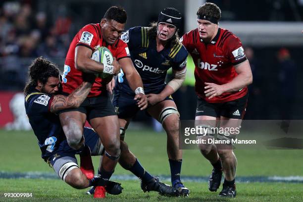 Seta Tamanivalu of the Crusaders is tackled by Jackson Hemopo of the Highlanders during the round 18 Super Rugby match between the Crusaders and the...