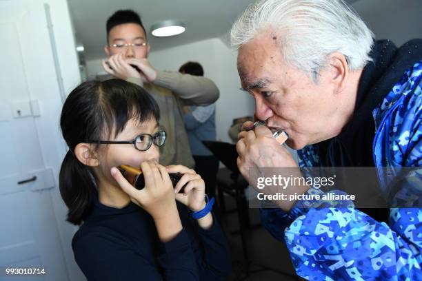 Lenng Tsz Kiu Amanda of the Kings College Old Boys Association from Hong Kong warms up with his harmonica in Trossingen, Germany, 1 November 2017....