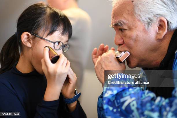 Dpatop - Lenng Tsz Kiu Amanda of the Kings College Old Boys Association from Hong Kong warms up with his harmonica in Trossingen, Germany, 1 November...