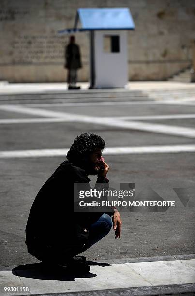 Man sits infront of the Greek parliament in central Athens on May 14, 2010. The head of Germany's biggest bank has cast doubt on whether debt-wracked...