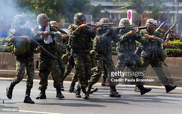 Soldiers shoot at red shirt anti-government protesters during clashes on May 14, 2010 in central Bangkok, Thailand. Protesters and military clashed...