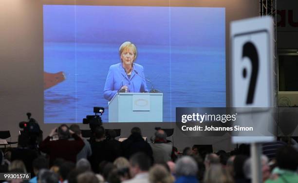 German Chancellor Angela Merkel, pictured on a giant screen delivers a speech during day 3 of the 2nd Ecumenical Church Day at International Congress...