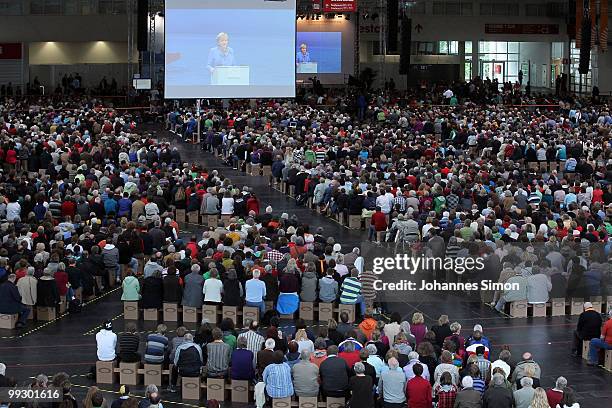 German Chancellor Angela Merkel, pictured on a giant screen delivers a speech during day 3 of the 2nd Ecumenical Church Day at International Congress...