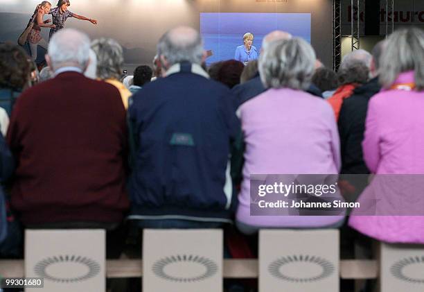 German Chancellor Angela Merkel, pictured on a giant screen delivers a speech during day 3 of the 2nd Ecumenical Church Day at International Congress...