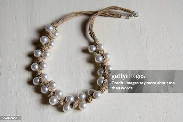 a rustic pearl necklace on a white background. - fashion glamour pearl stock pictures, royalty-free photos & images