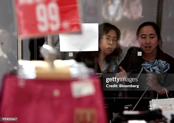 Customers browse the window display at the Uniqlo store owned by Fast Retailing Co., in Shanghai, China, on Friday, May 14, 2010. Fast Retailing Co....