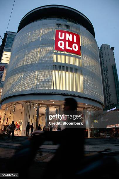 Traffic passes the Uniqlo store owned by Fast Retailing Co., in Shanghai, China, on Friday, May 14, 2010. Fast Retailing Co. Plans to increase the...