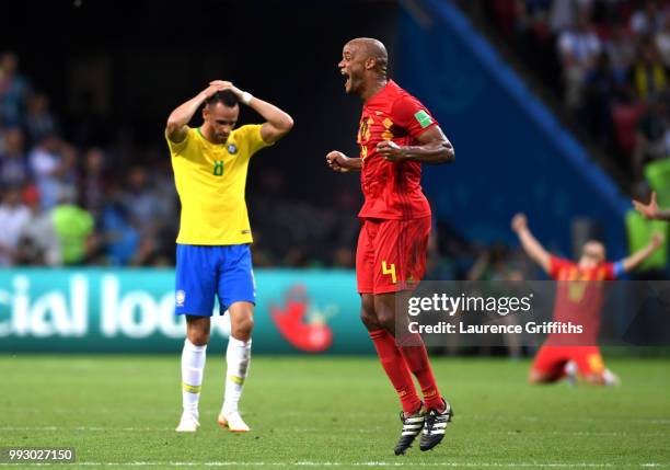 Renato Augusto of Brazil looks dejected as Vincent Kompany of Belgium celebrates following the 2018 FIFA World Cup Russia Quarter Final match between...
