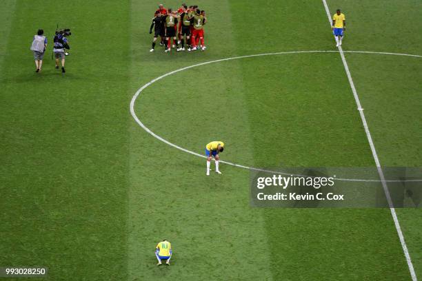 Neymar Jr and Renato Augusto of Brazil look dejected while Belgium players celebrate victory following the 2018 FIFA World Cup Russia Quarter Final...