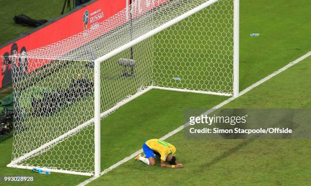 Neymar of Brazil presses his face to the turf as his team are defeated during the 2018 FIFA World Cup Russia Quarter Final match between Brazil and...