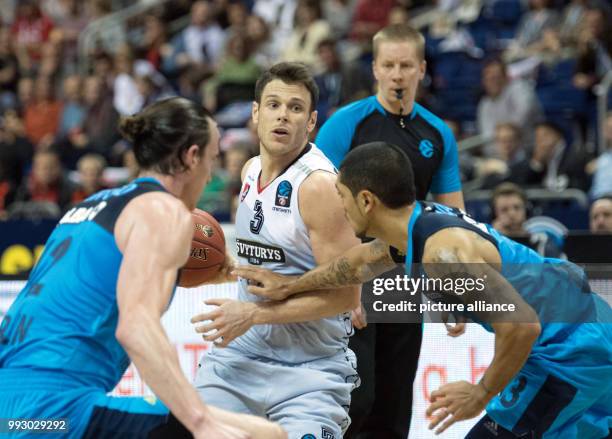 Alba's Dennis Clifford and Vilnius' Peyton Siva and Chris Kramer vie for the ball during the Eurocup basketball match between ALBA Berlin and...