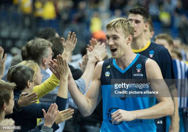 Alba's Niels Giffey and his team celebrating victory and high-fiving the fans after the Eurocup basketball match between ALBA Berlin and Lietuvos...