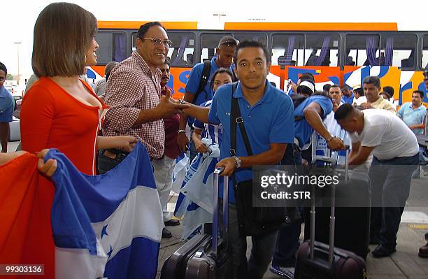 Honduran player Danilo Turcios is greeted by supporters as he comes down the bus at Ramon Villeda Morales airport in San Pedro Sula, 240 km north of...