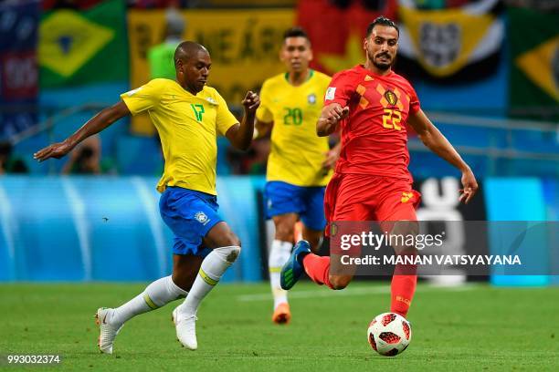 Belgium's midfielder Nacer Chadli passes the ball as he is marked by Brazil's midfielder Fernandinho during the Russia 2018 World Cup quarter-final...