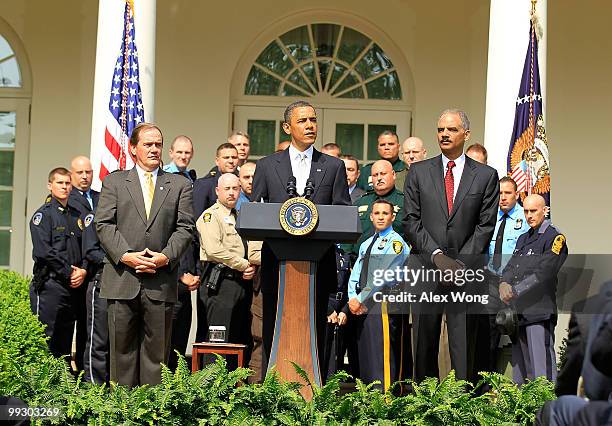 President Barack Obama speaks as Attorney General Eric Holder and President of NAPO Tom Nee listen during a Rose Garden event to honor winners of the...