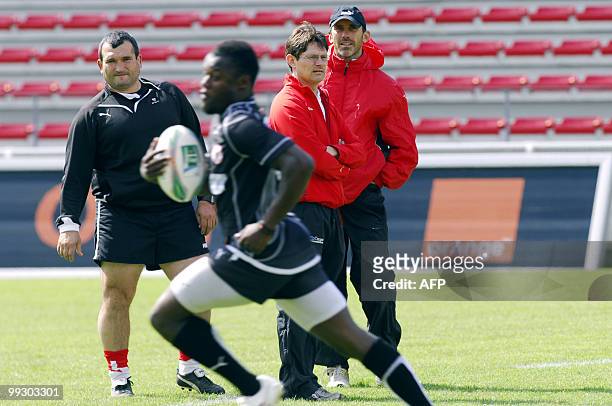 Biarritz's Jack Isaac looks at his teammate Takudzwa Ngwenya running near physical therapist Jean-michel Gonzalez on May 14, 2010 during a training...