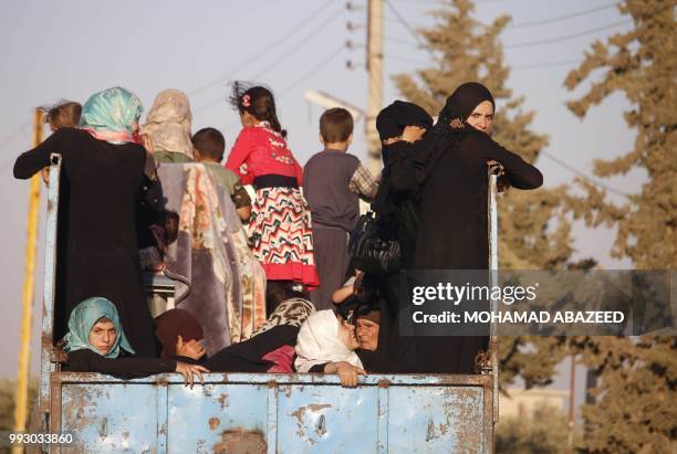 Syrian families return to their homes in towns and villages situated on the eastern outskirts of Daraa on July 6, 2018. - The Syrian regime reached a...