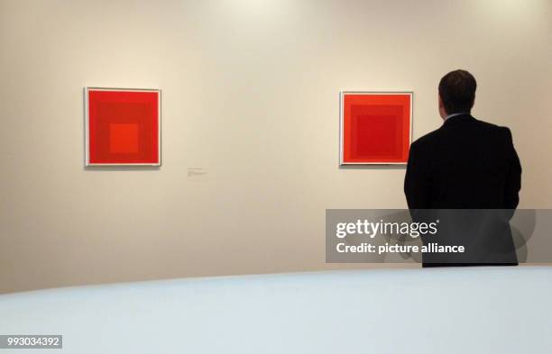 Man stands in front of paintings of the series 'Hommage to the Square' by Josef Albers at the exhibition at the Guggenheim Museum in New York, US, 2...