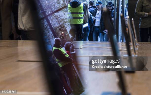 People can be seen at an Apple Store, waiting to purchase the new iPhone X in Hamburg, Germany, 3 November 2017. Photo: Paul Zinken/dpa