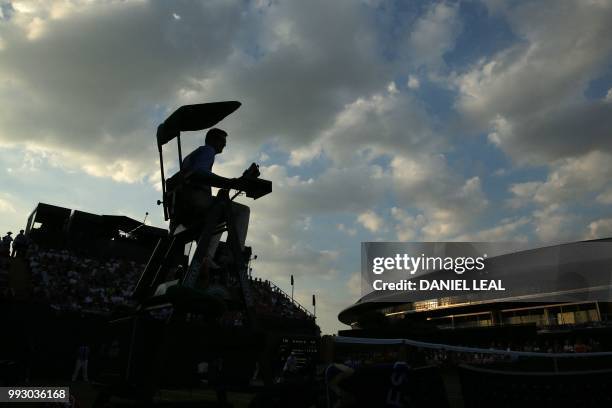 The umpire is silhouetted as Argentina's Guido Pella plays US player Mackenzie McDonald during their men's singles third round match on the fifth day...
