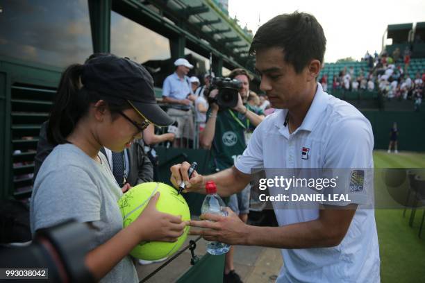 Player Mackenzie McDonald autographs a ball after playing Argentina's Guido Pella during their men's singles third round match on the fifth day of...