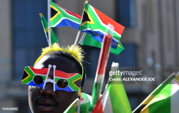 South African street vendor selling flags and sunglasses in the image of the South African flag touts he wares in Johannesburg on May 14, 2010. Less...